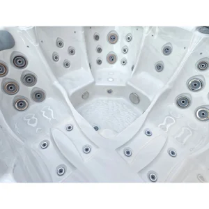 Nahaufnahme des weißen Acryl-Innenlebens des Whirlpools Gamma 323, wobei der Fokus auf den verschiedenen Arten von Massagedüsen (Größe und Stil) und ergonomischen Sitzbereichen liegt.