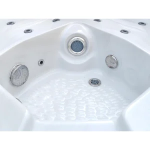 Nahaufnahme des weißen Whirlpool-Beckenbodens mit geriffelter rutschfester Textur, Hauptabfluss, großen Ansaugöffnungen und Massagedüsen.